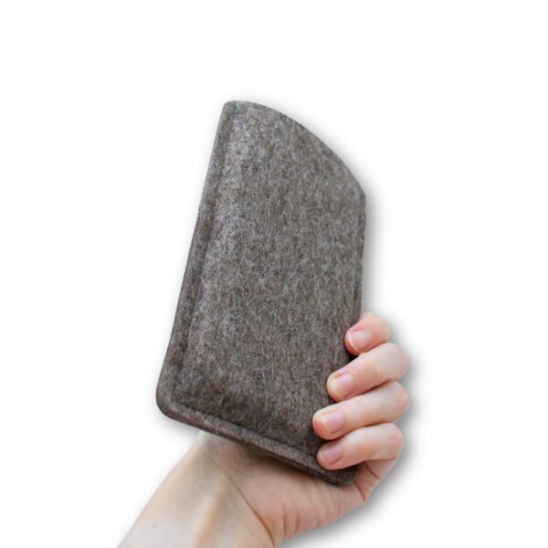 Handyhülle aus grauem Filz und grünem Kork, Ansicht von hinten, in einer Hand gehalten