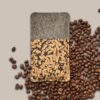 Handyhülle aus grauen Filz mit Kork und Kaffee, umgeben von Kaffeebohnen