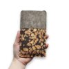 Handytasche aus grauem Filz und Kork mit Kaffee, Fleckenmuster, in einer Hand gehalten