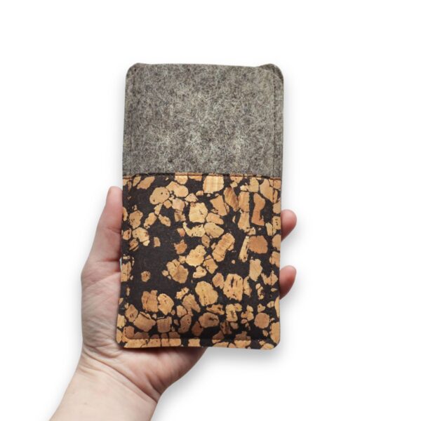 Handytasche aus grauem Filz und Kork mit Kaffee, Fleckenmuster, in einer Hand gehalten