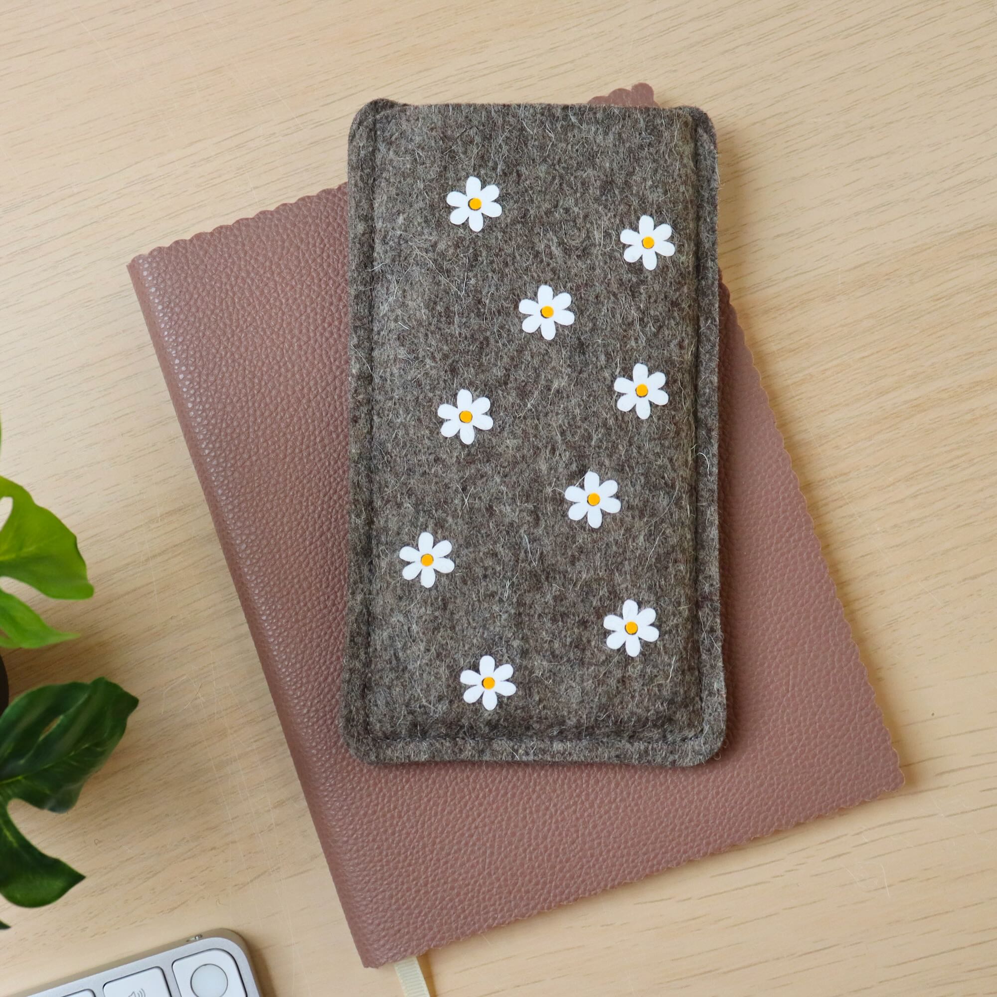 Handytasche aus Wollfilz mit Blumen-Allover-Print, auf einem Schreibtisch liegend
