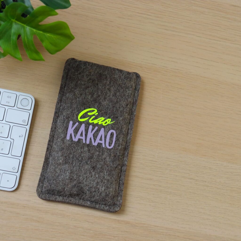 Handytasche aus grauem Filz mit Print "Ciao Kakao", Schreibtischszene