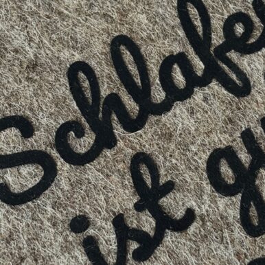 Graue Filzhülle für PocketBook Verse, mit schwarzem Flockprint "Schlafen ist gut, lesen ist besser.", Detailansicht