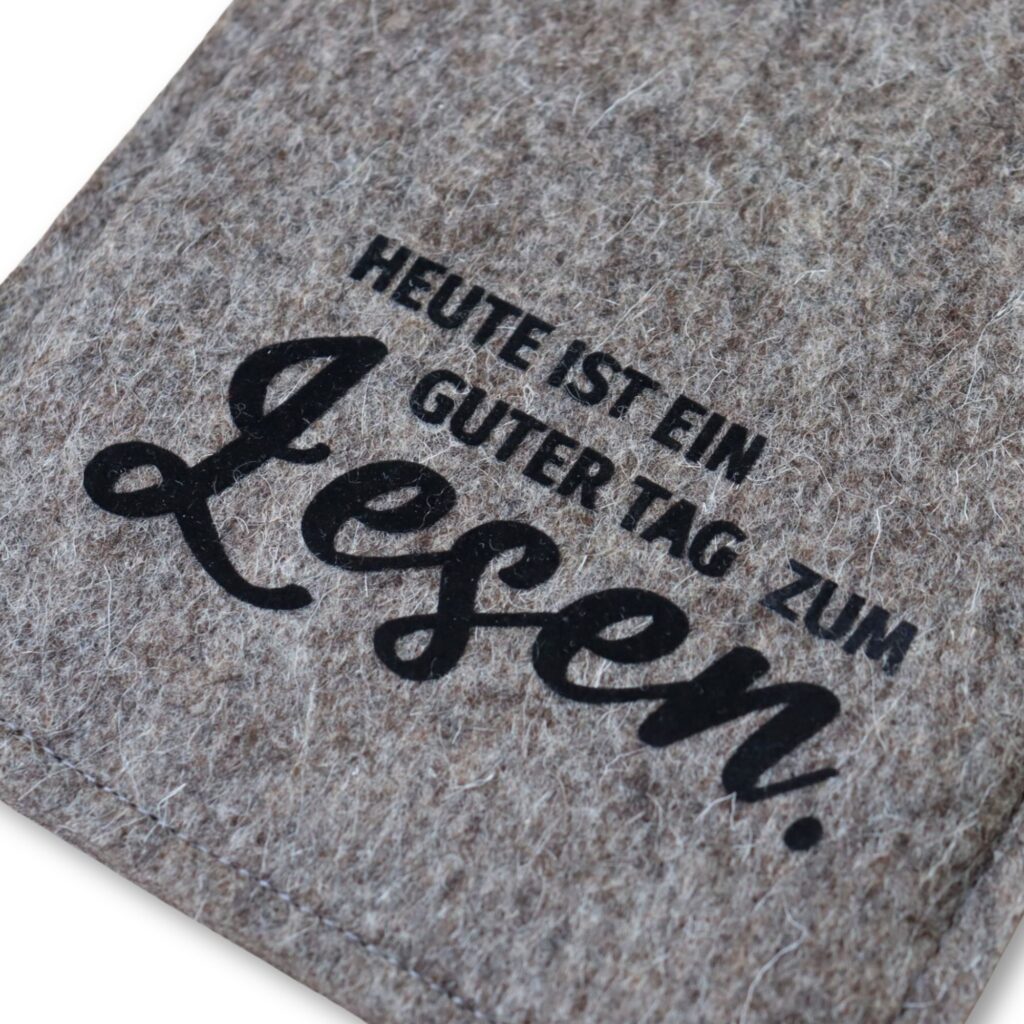 Hülle für eBook Reader aus grauem Wollfilz mit schwarzem Flockprint "Heute ist ein guter Tag zum Lesen."