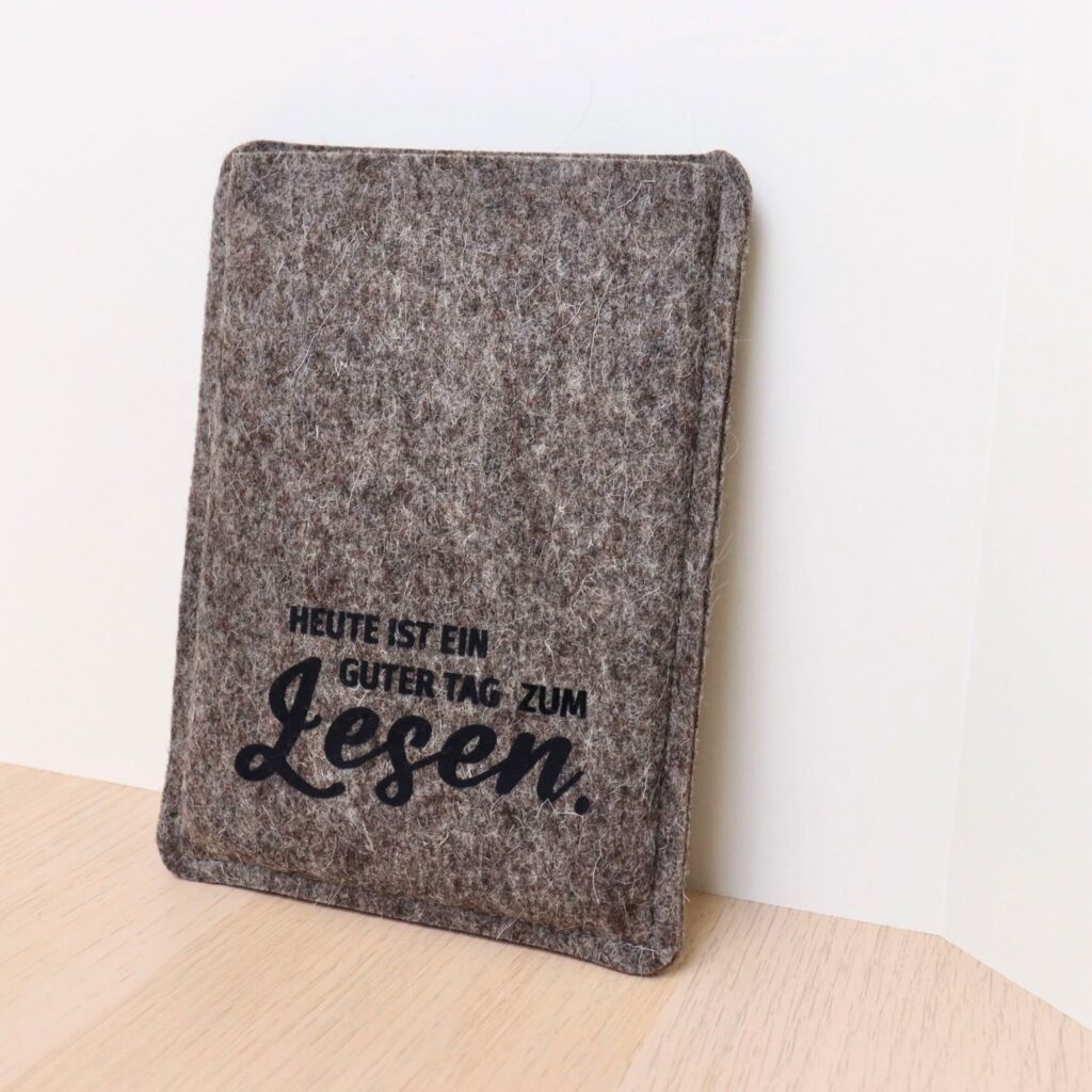 Hülle für eBook Reader aus grauem Wollfilz mit schwarzem Flockprint "Heute ist ein guter Tag zum Lesen."