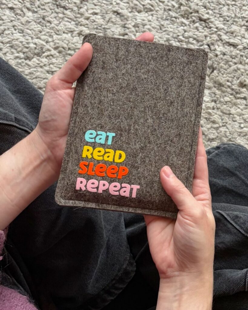 eReader Hülle aus grauem Wollfilz, mit buntem Schriftzug "eat read sleep repeat", einfache Einschubhülle für eBook Reader