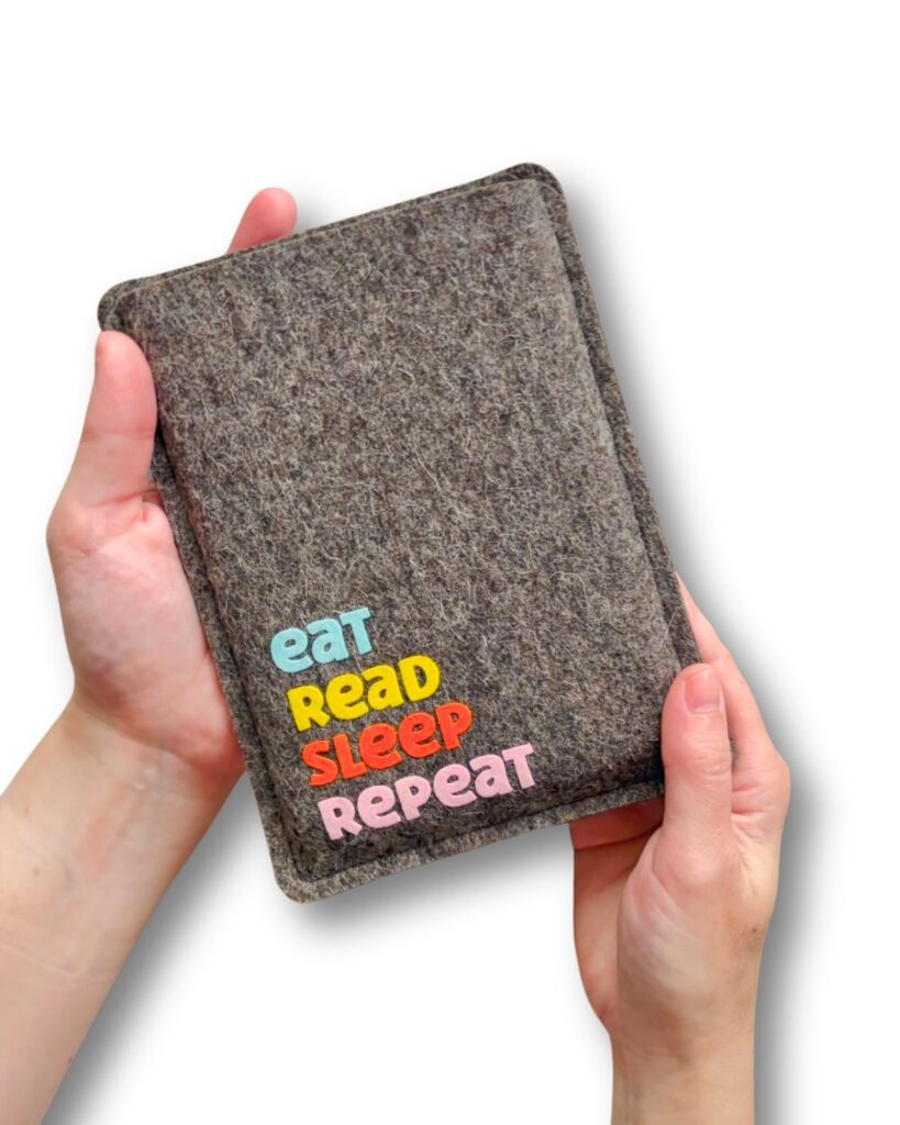 eReader Hülle aus grauem Wollfilz, mit buntem Schriftzug "eat read sleep repeat", einfache Einschubhülle für eBook Reader