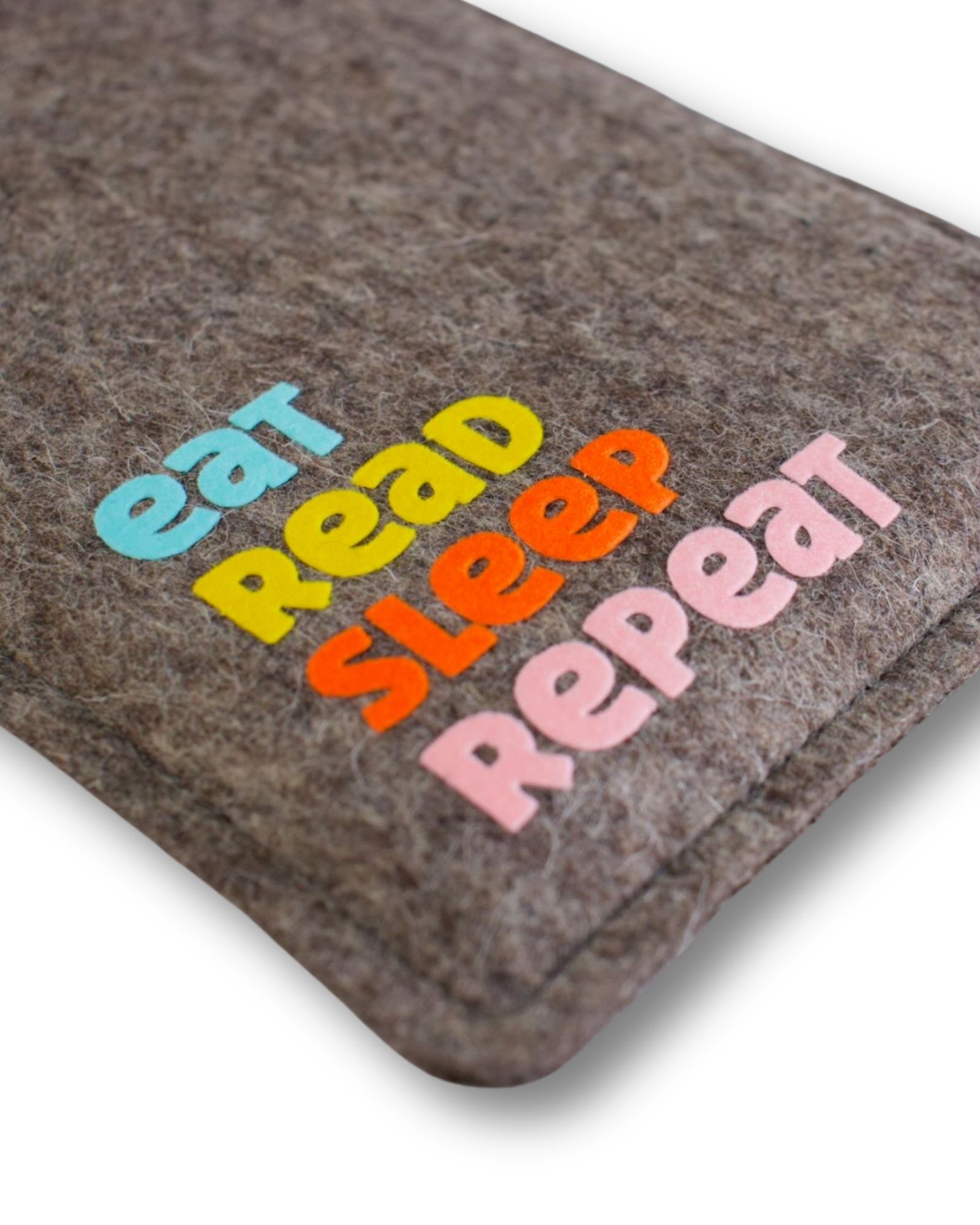 eReader Hülle aus grauem Wollfilz, mit buntem Schriftzug "eat read sleep repeat", einfache Einschubhülle für eBook Reader, Detailansicht